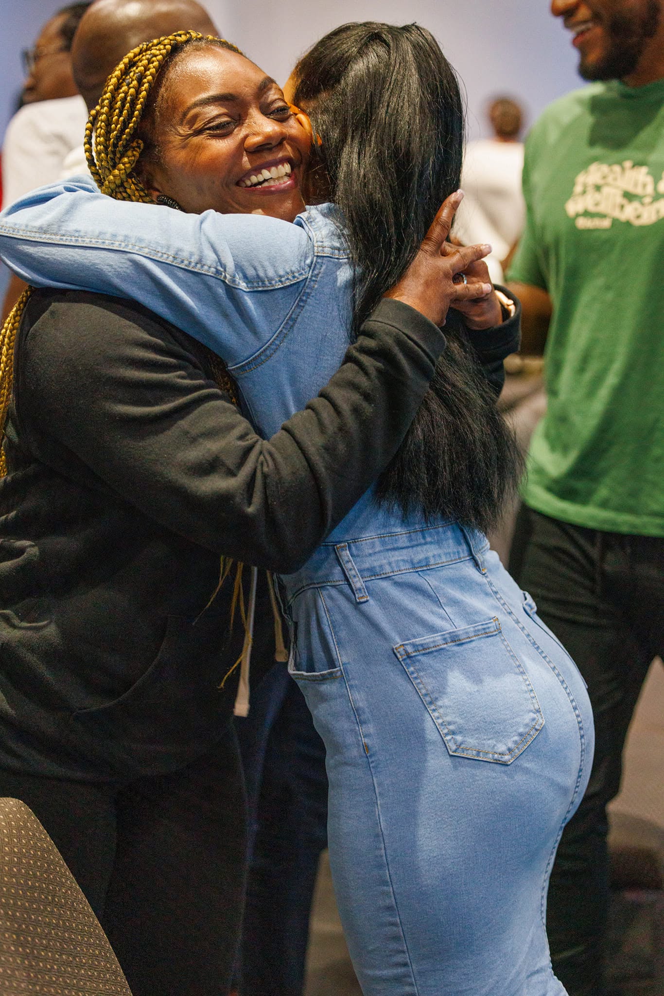 Two Atlanta Church Creatives members greeting each other with a joyful hug